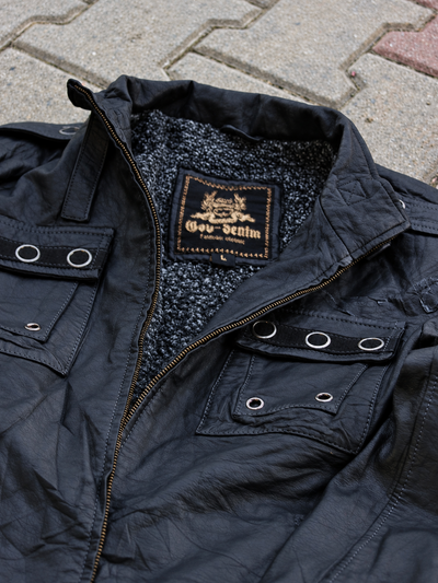 Close-up of black jacket collar, brand label, textured lining and eyelet chest pockets