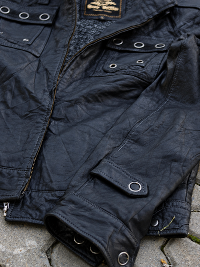 Black jacket eyelet cuff strap, sleeve texture and chest pocket detail