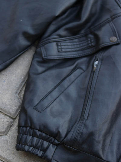 Close-up of black jacket zip pocket and elasticated hem