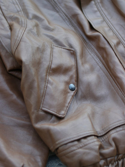 Brown jacket pocket flap and snap fastening detail