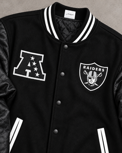 Close-up of AFC and Raiders chest patches, black snaps, striped collar and wool texture